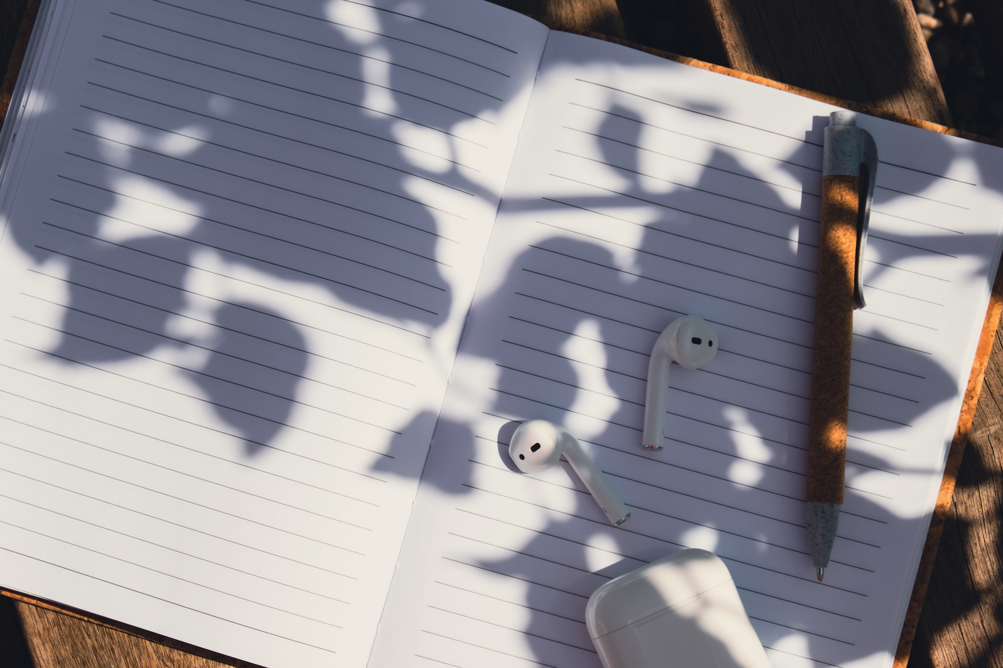Paper notebook with wireless headphones. Mockup Coffee break. Audio healing, sound therapy wellness. Anonymität spielt eine wichtige Rolle bei der Behandlung von Essstörungen.